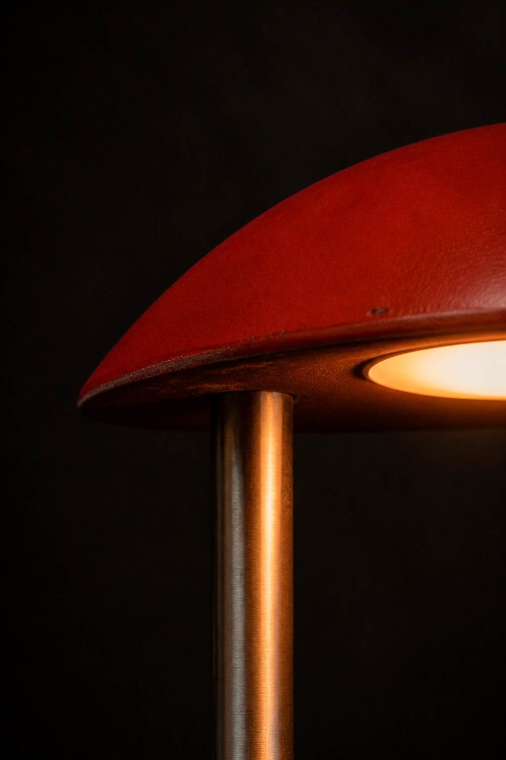 Synthetic macro photograph showing worn red powder coat and brushed metal direction